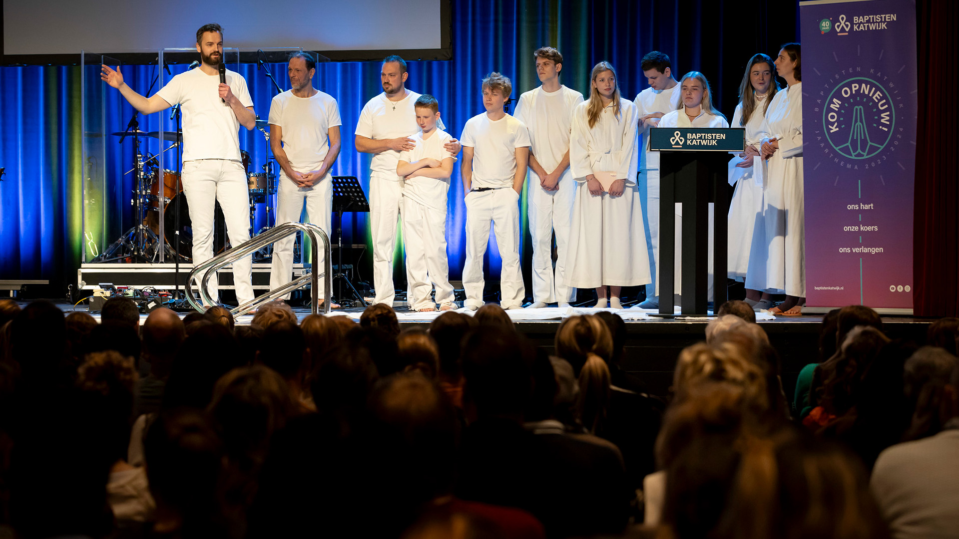 Negen jongeren in witte kleding tijdens doopdienst bij Baptistengemeente Katwijk – Doopdienst met negen jonge mensen
