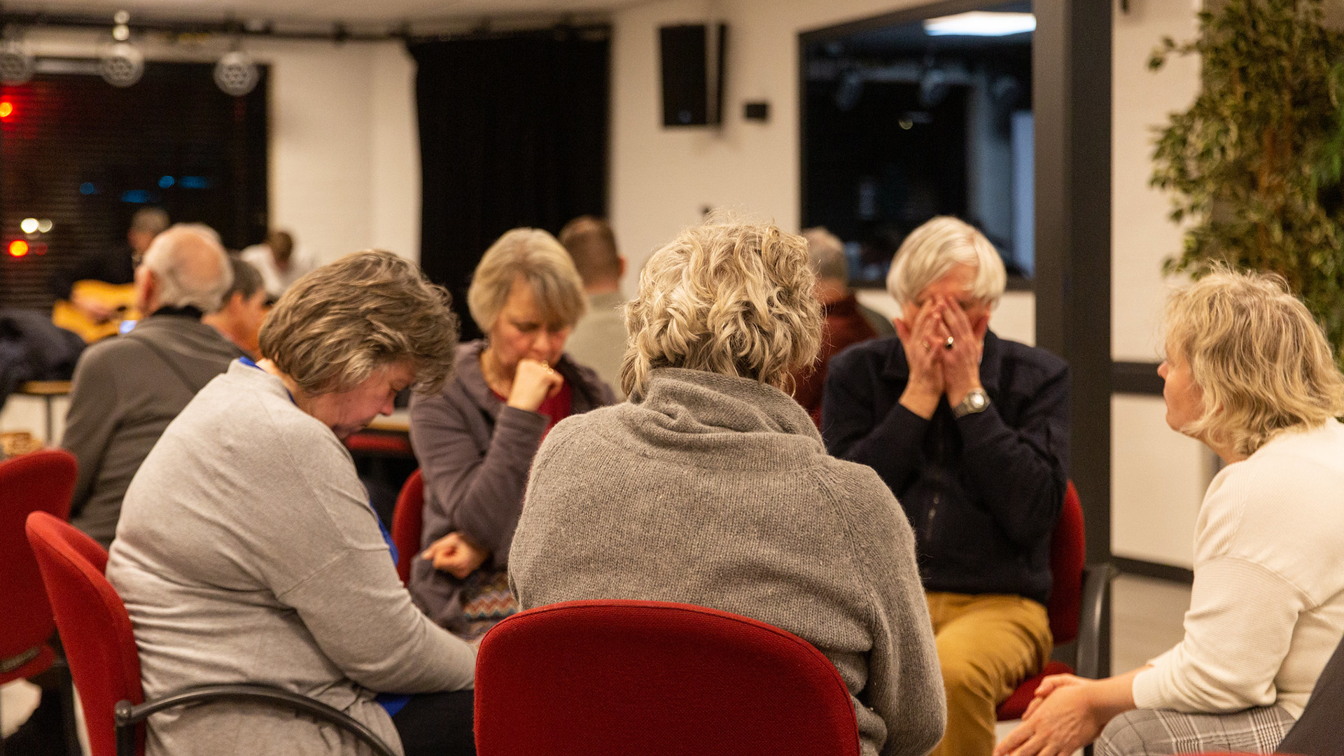 Groep gelovigen bidt samen tijdens Nacht van Gebed voor vervolgde c – Op ongemakkelijke tijd bidden voor vervolgde christenen