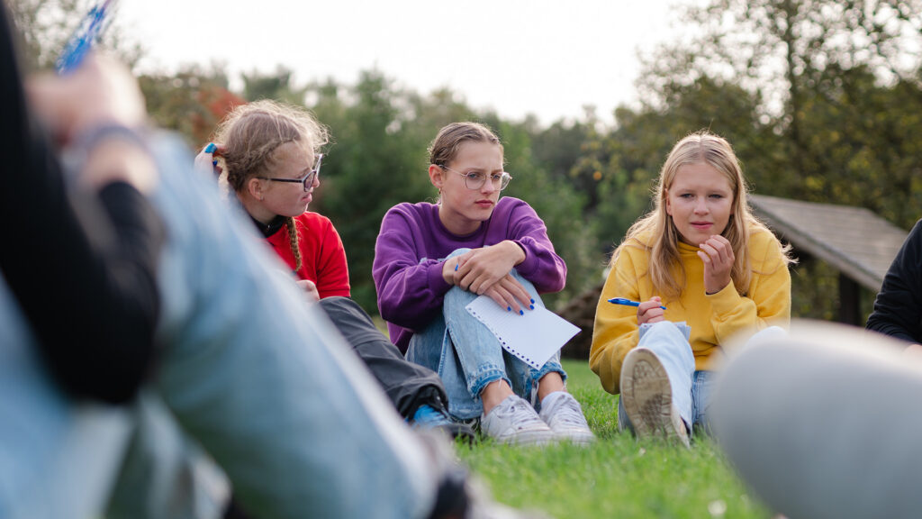 Groep tieners luistert aandachtig tijdens jeugdavond Jeugdleiders – Jeugdleiders gezocht voor  de nieuwe eerstejaars jongeren